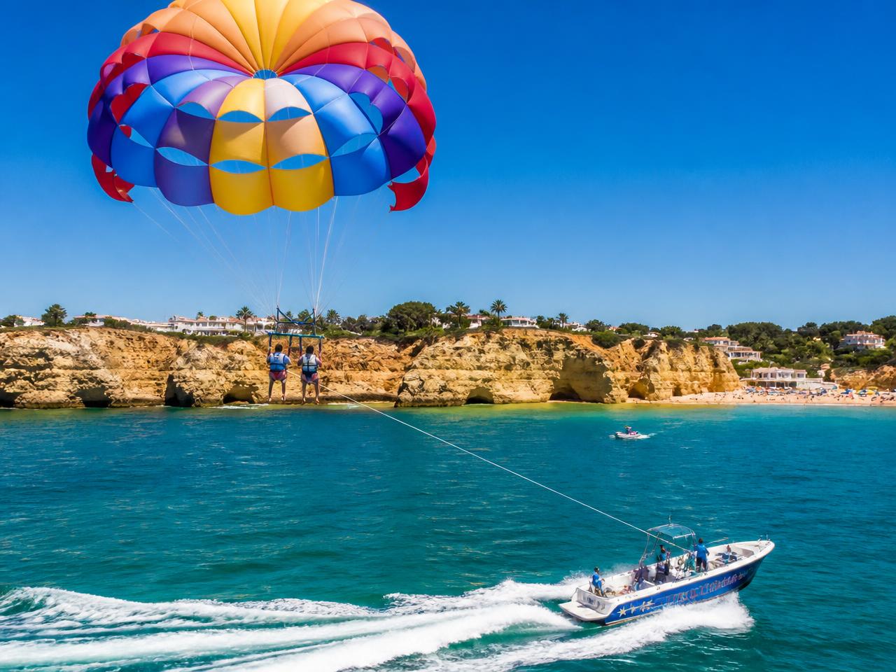 Parasail canopy towed above the turquoise water off the Algarve coast