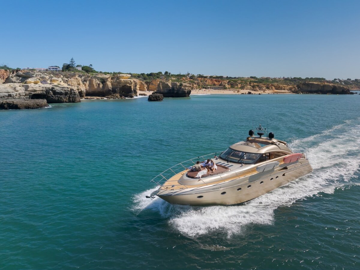 Private luxury yacht charter cruising past the golden cliffs and turquoise water of the Algarve coastline near Albufeira